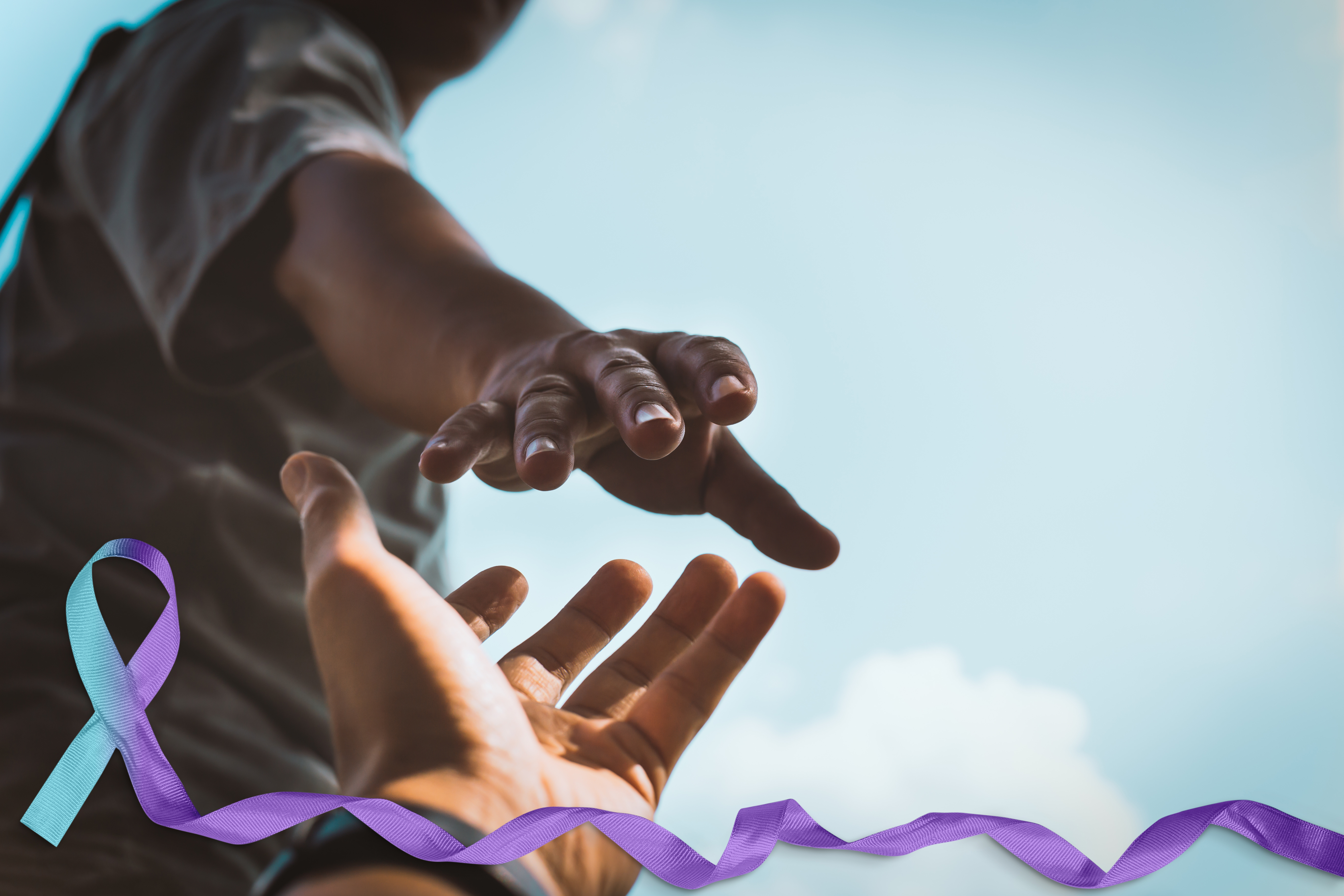 person reaching out to another hand with ribbon