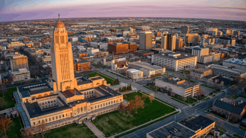 Aerial view of sunset over downtown Lincoln, Nebraska, with the Capitol building prominently visible.