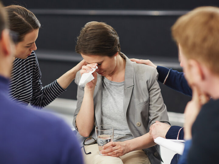 people consoling crying woman